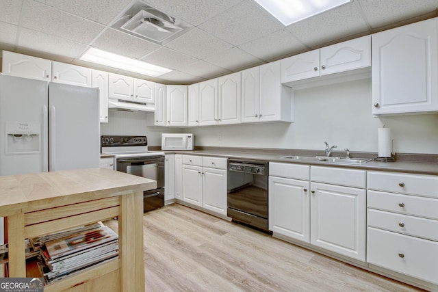 kitchen featuring a drop ceiling, white cabinets, white appliances, and sink