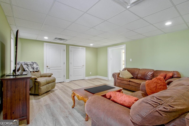 living room featuring a paneled ceiling and light wood-type flooring