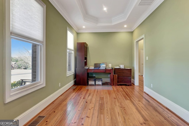 office space featuring plenty of natural light, a raised ceiling, and crown molding