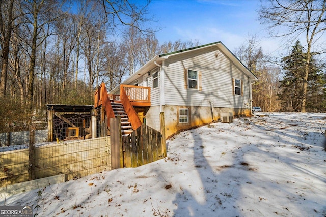 view of snow covered exterior with cooling unit and a wooden deck