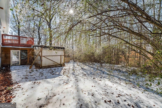 yard layered in snow featuring a wooden deck