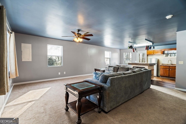 living room with carpet flooring, ceiling fan, and sink