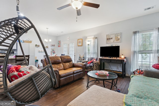 living room featuring dark wood-type flooring and ceiling fan with notable chandelier