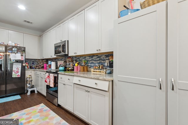 kitchen featuring light stone counters, dark wood-type flooring, white cabinets, and stainless steel appliances