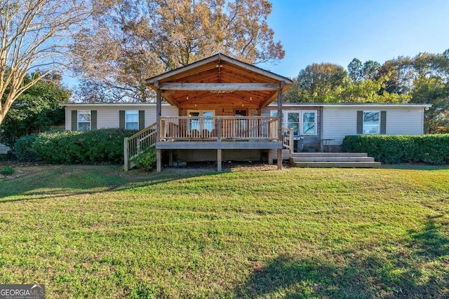 rear view of property with a deck and a yard