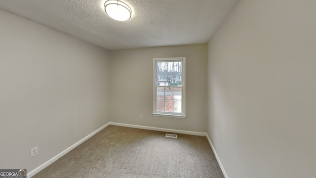 carpeted spare room with a textured ceiling