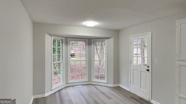 foyer entrance featuring a textured ceiling and light hardwood / wood-style flooring