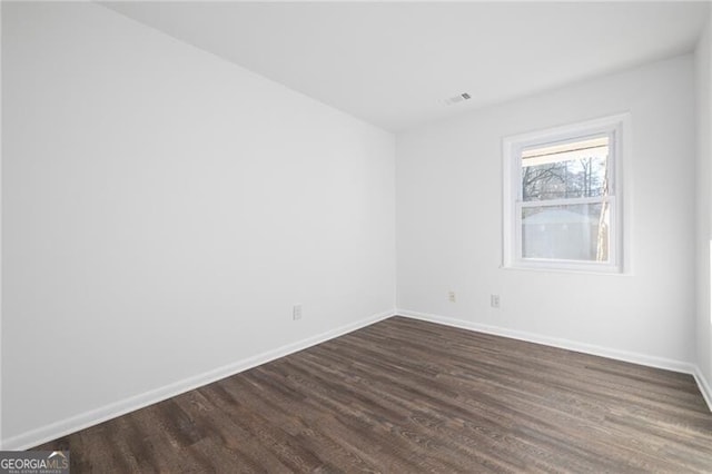 spare room featuring dark wood-type flooring