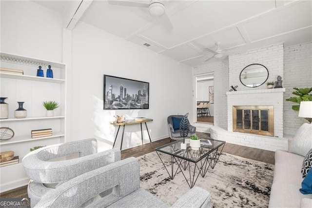 living room featuring ceiling fan, a fireplace, built in features, and hardwood / wood-style flooring