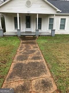 view of front of house with a porch and a front yard