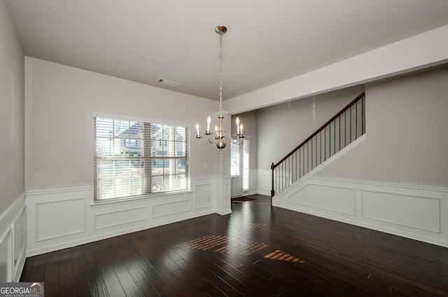 unfurnished dining area with dark hardwood / wood-style flooring and an inviting chandelier