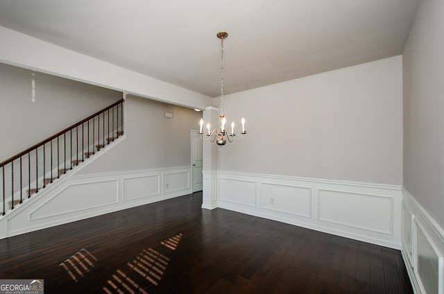 unfurnished dining area featuring dark hardwood / wood-style flooring and a notable chandelier