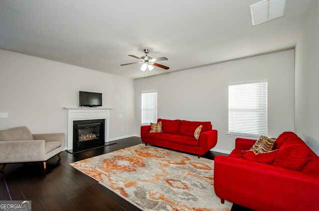 living room featuring ceiling fan and dark hardwood / wood-style flooring