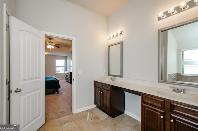 full bath featuring double vanity, connected bathroom, a sink, baseboards, and tile patterned floors