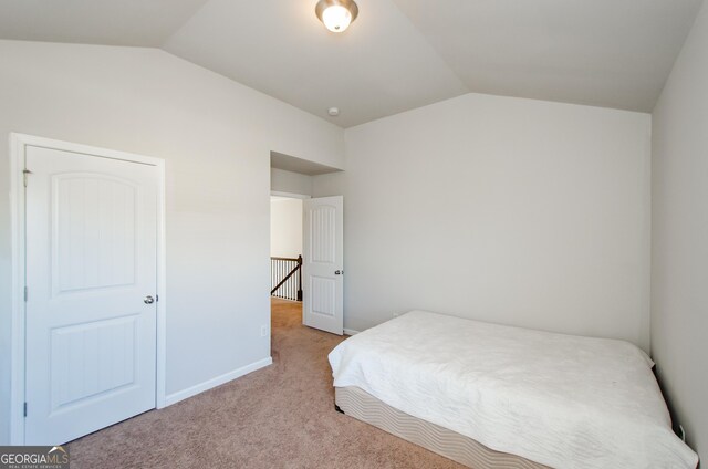 bedroom with light carpet and vaulted ceiling