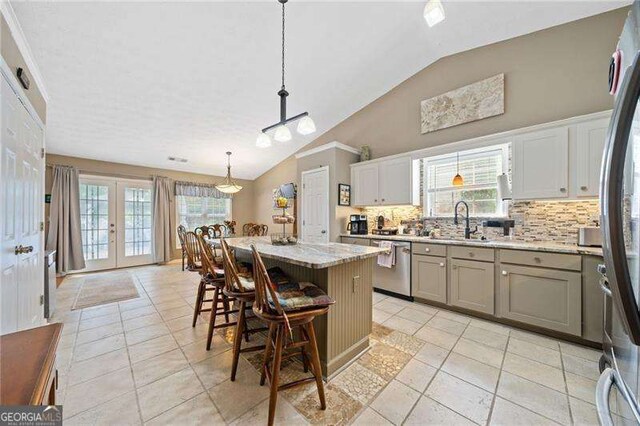 kitchen featuring a breakfast bar area, a kitchen island, decorative light fixtures, and lofted ceiling