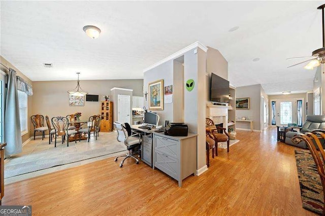 home office with a textured ceiling, light hardwood / wood-style flooring, and ceiling fan