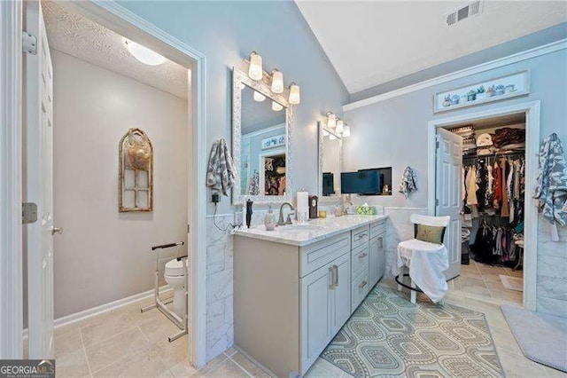 bathroom featuring vanity, lofted ceiling, crown molding, toilet, and a textured ceiling