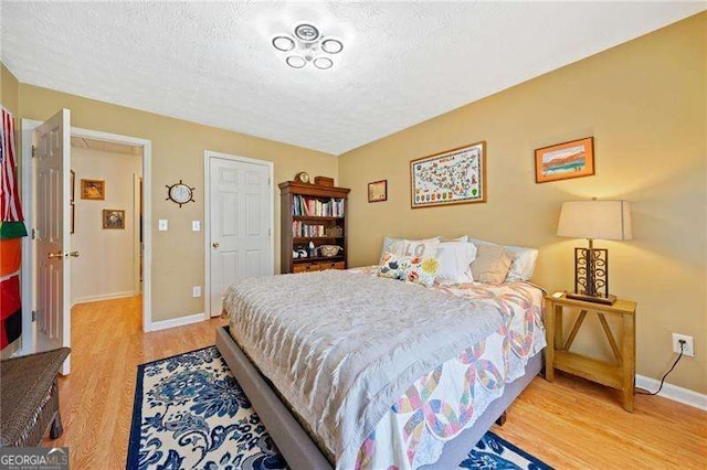 bedroom with wood-type flooring and a textured ceiling