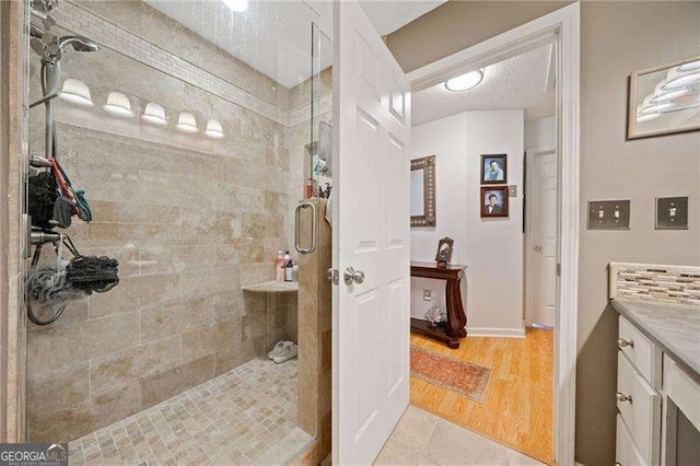 bathroom featuring vanity, wood-type flooring, and a shower with shower door