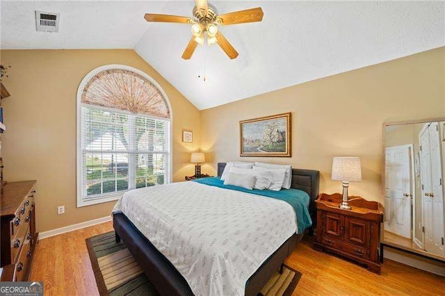 bedroom with baseboard heating, light hardwood / wood-style flooring, ceiling fan, and lofted ceiling