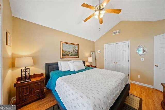 bedroom featuring ceiling fan, vaulted ceiling, light hardwood / wood-style flooring, and a closet