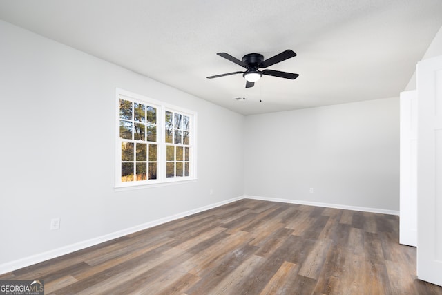 unfurnished room featuring ceiling fan and dark hardwood / wood-style flooring