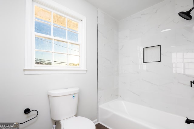 bathroom featuring toilet and tiled shower / bath