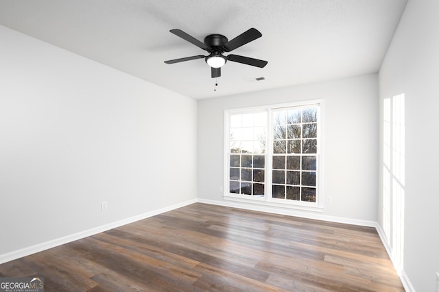 empty room featuring dark hardwood / wood-style floors and ceiling fan