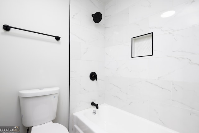 bathroom with toilet and tiled shower / bath combo