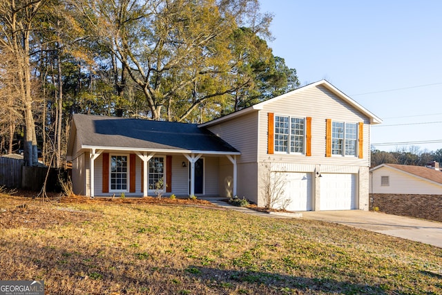 tri-level home with a garage, covered porch, and a front lawn