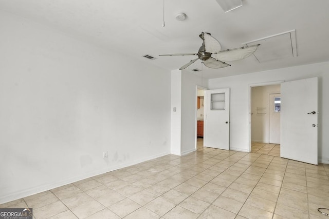 spare room with ceiling fan and light tile patterned floors