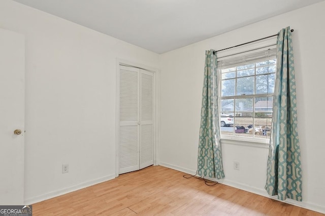 unfurnished bedroom with hardwood / wood-style floors and a closet