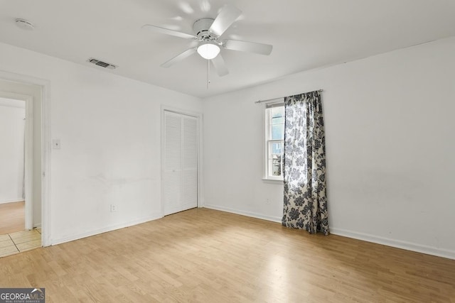 empty room featuring light wood-type flooring and ceiling fan