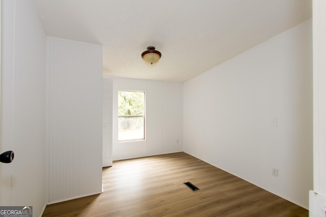 unfurnished room with hardwood / wood-style flooring