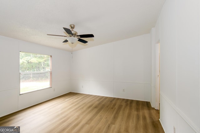 empty room with ceiling fan and wood-type flooring