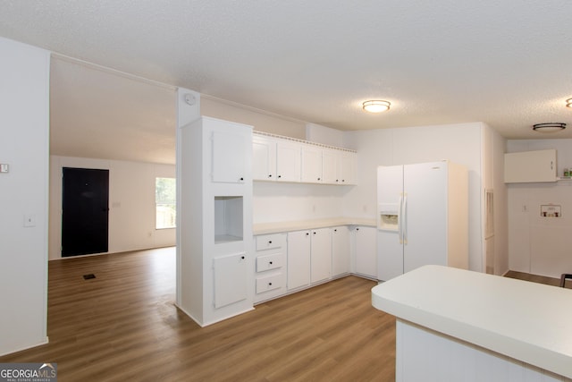 kitchen featuring light hardwood / wood-style floors, white cabinetry, white refrigerator with ice dispenser, and a textured ceiling