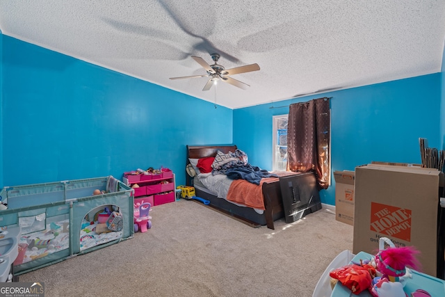 carpeted bedroom featuring ceiling fan and a textured ceiling