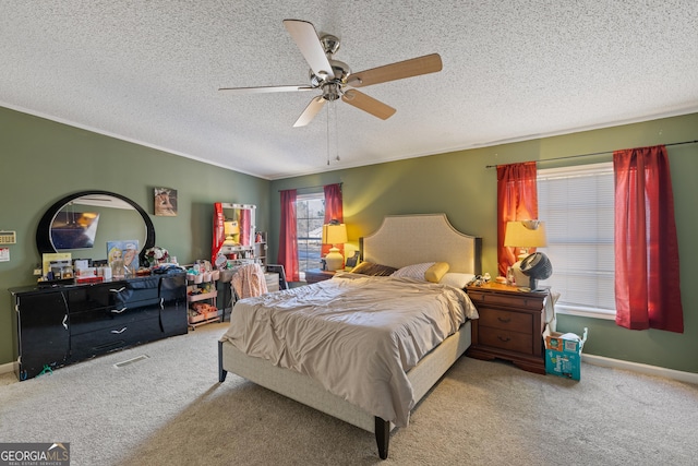 bedroom with ceiling fan, carpet floors, and a textured ceiling