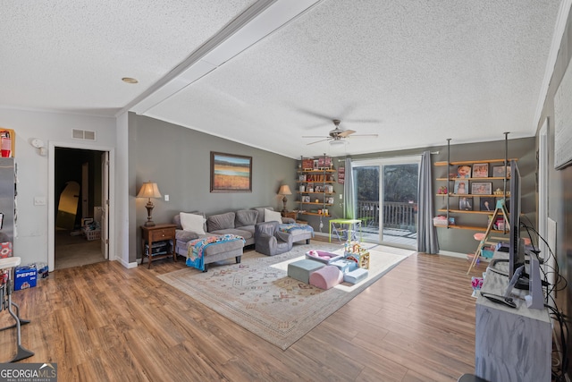 living room with a textured ceiling, lofted ceiling, and hardwood / wood-style flooring