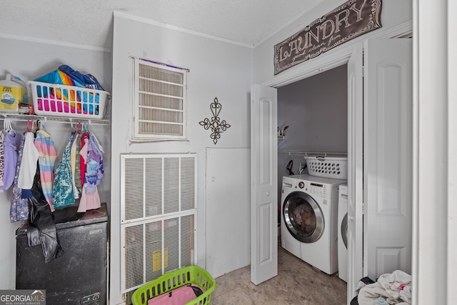 laundry room with a textured ceiling and washing machine and clothes dryer