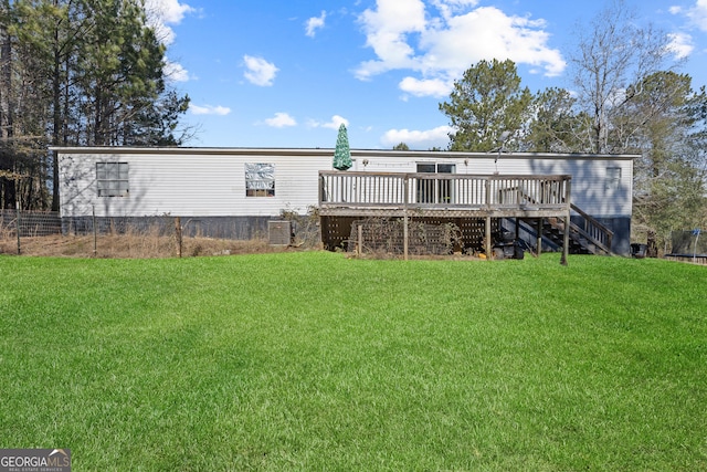 back of house featuring a wooden deck and a yard