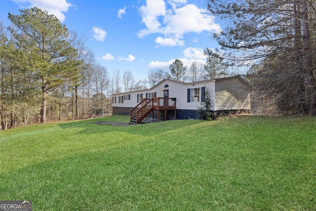 rear view of house featuring a yard and a wooden deck