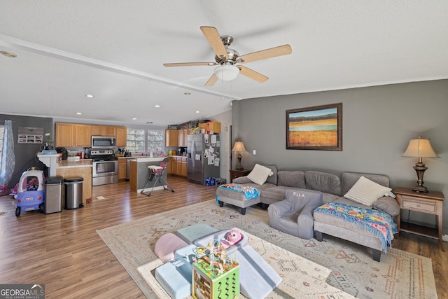 living room featuring a textured ceiling, ceiling fan, hardwood / wood-style floors, and vaulted ceiling