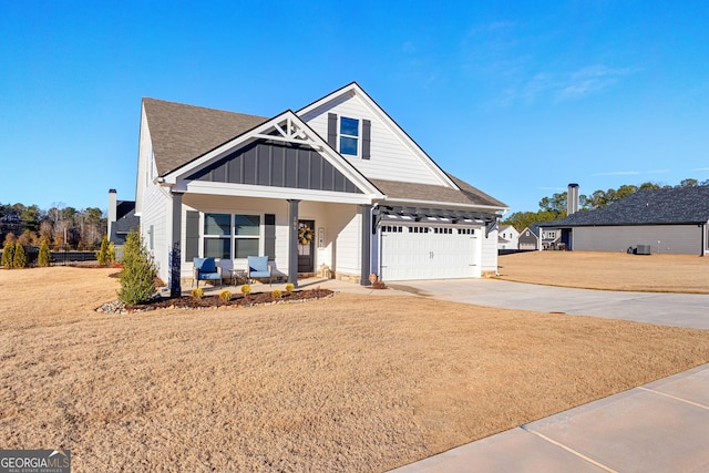 view of front of home featuring a garage, covered porch, and a front lawn