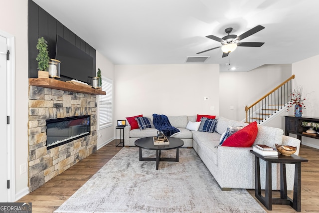 living room featuring a fireplace, ceiling fan, and hardwood / wood-style floors