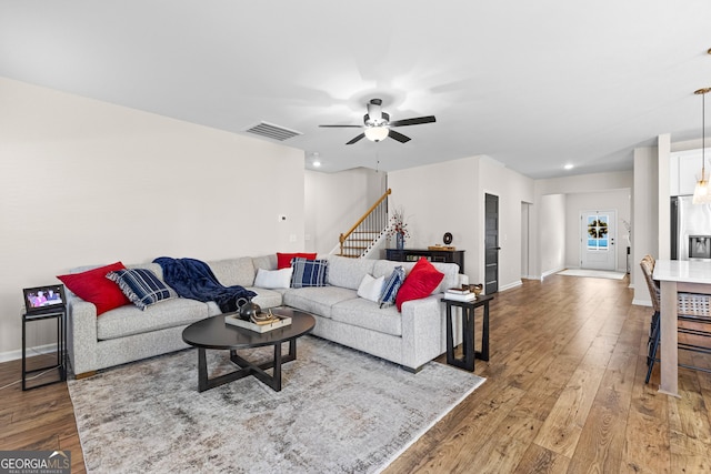 living room featuring ceiling fan and hardwood / wood-style flooring