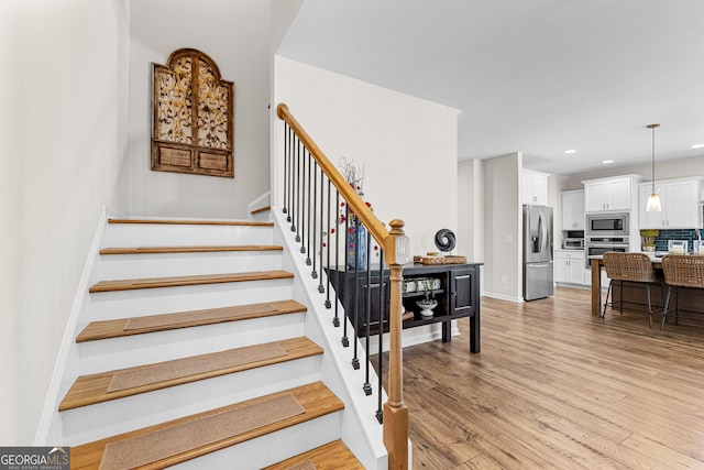 staircase with hardwood / wood-style floors