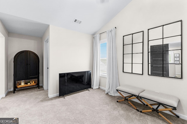 carpeted living room with lofted ceiling