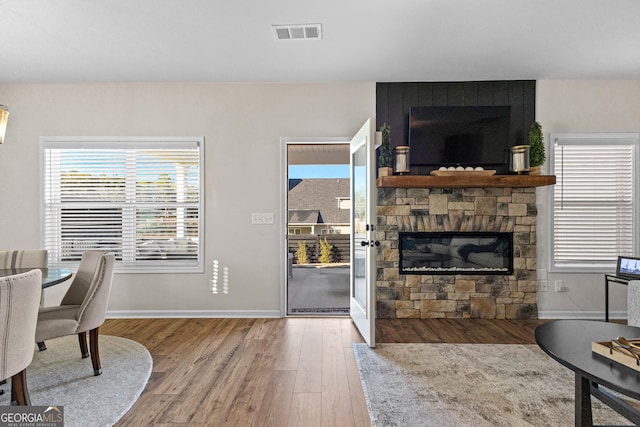 interior space featuring wood-type flooring and a stone fireplace